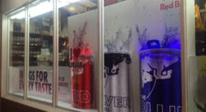 Red bull cans on display in a specialty store window.